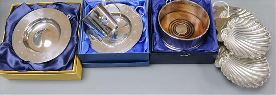 An Arts & Crafts silver and enamel Christening mug, a silver bottle coaster, two silver dishes and three shell butter dishes,